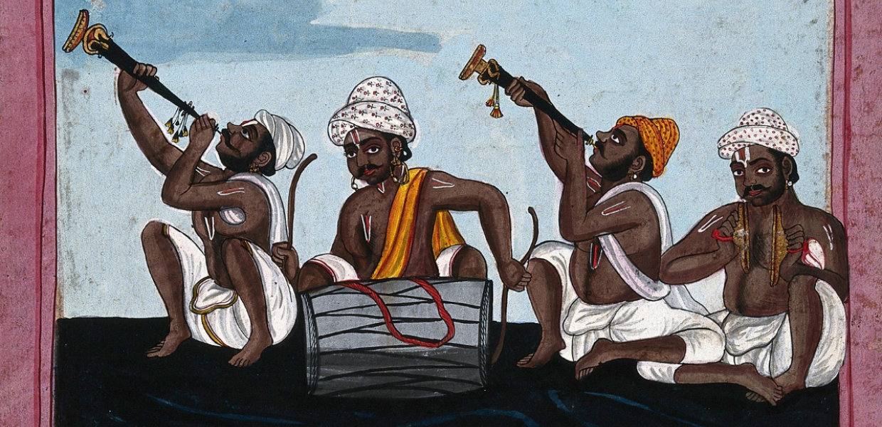Four seated Indian musicians play instruments